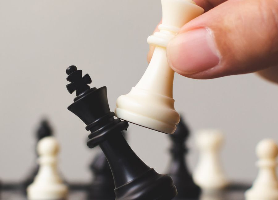 Hand moving a chess piece across the board